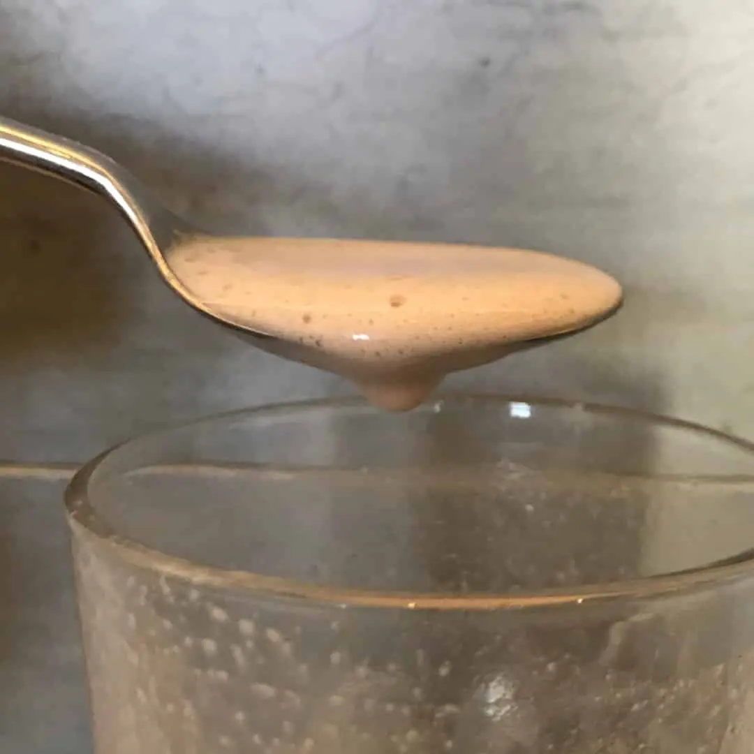 Cremige Konsistenz des damaligen All Stars Chocolate Shakes mit Milch auf einem Löffel