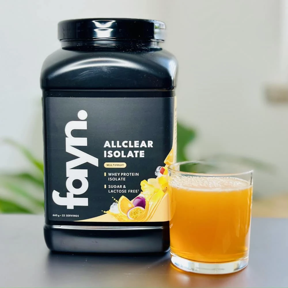 Unsere Multifruit-Testdose neben dem kräftig orangefarbenen fayn-ALLCLEAR-Getränk