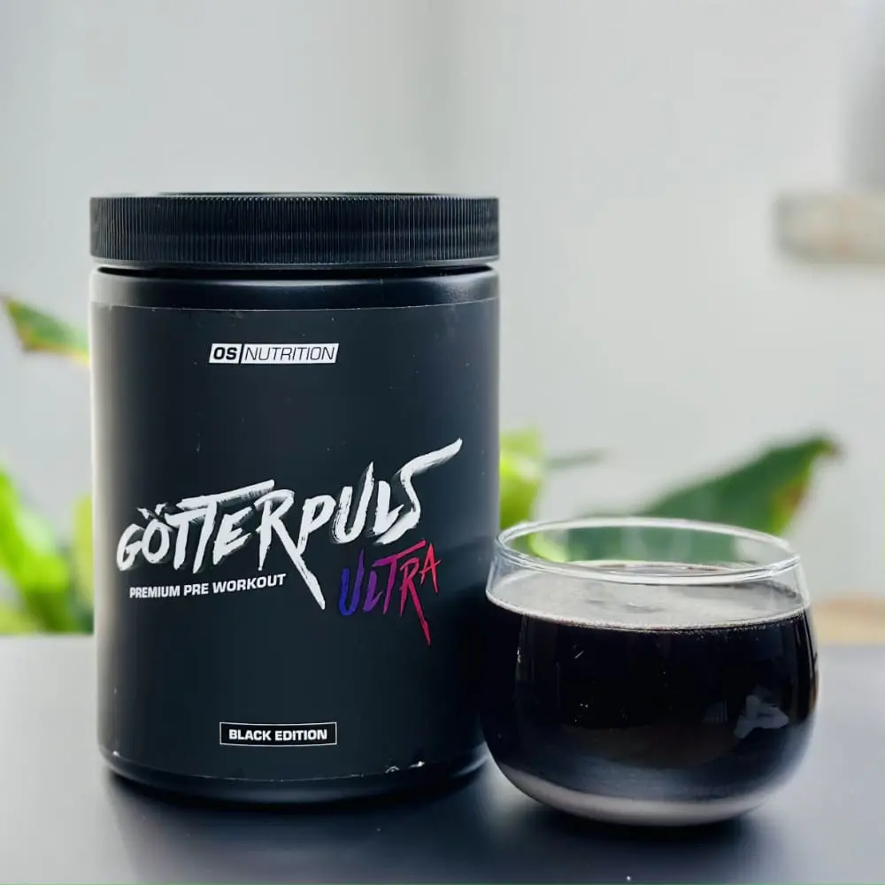 Unsere Götterpuls-Ultra-Black-Edition-Dose neben dem dunkelvioletten Drink im Glas