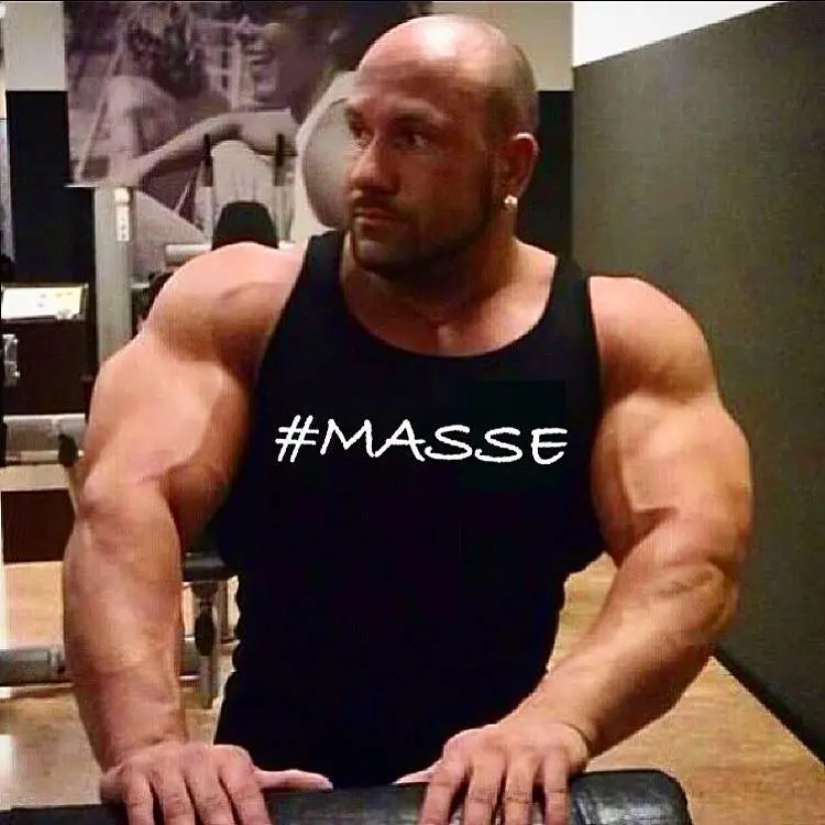Steve Benthin im Fitnessstudio mit einem Tanktop mit der Aufschrift Masse
